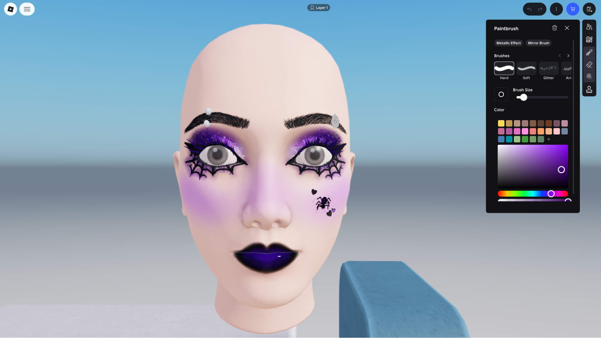 Roblox in-experience makeup creation tool showing a Halloween-style purple eyeshadow and spiderweb design on an avatar head with the Paintbrush panel open